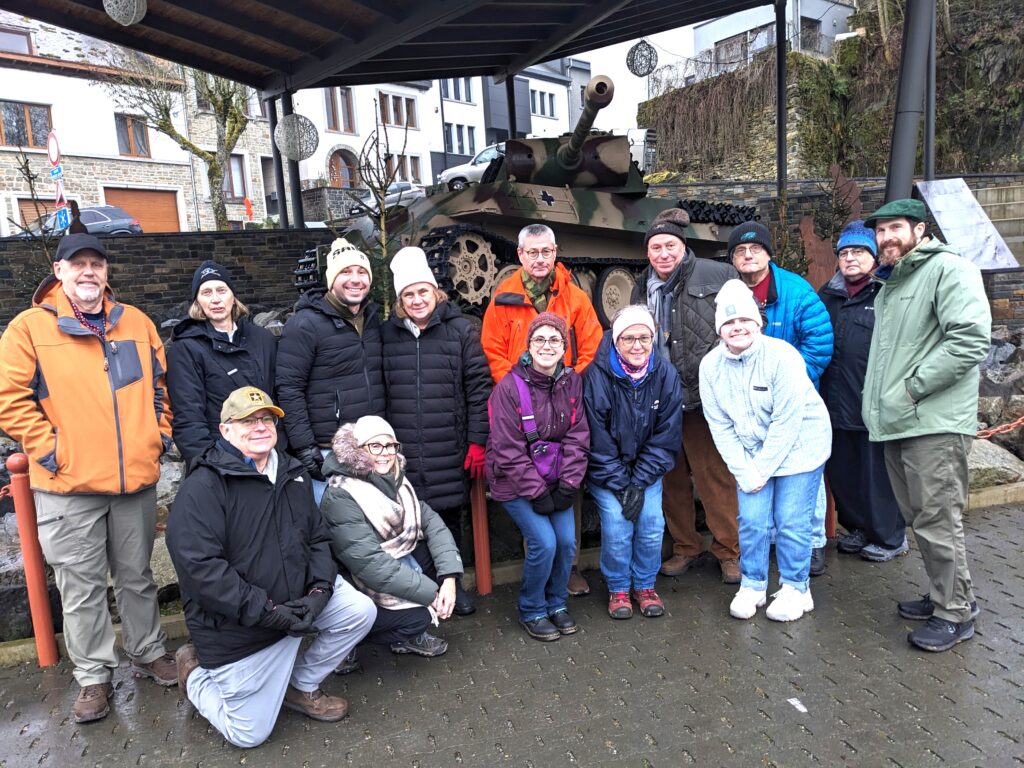 Explore the Ardennes "Battle of the Bulge" on our December tour. Here, 2024 tour participants stand in front of the German Panther Tank at Houffalize, Belgium.
